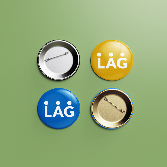 Freigestellte Buttons mit Logo der LAG Selbsthilfe auf grünem Hintergrund. Die Buttons sind blau und gelb. Das Logo der LAG Selbsthilfe ist weiß und besteht aus den drei Buchstaben 